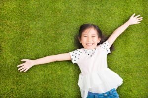 happy Little girl resting on the grass